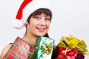 Image showing blue-eyed beautiful girl in santa hat with presents