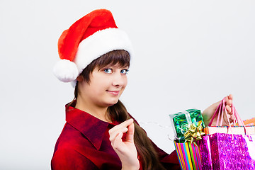 Image showing blue-eyed beautiful girl in santa hat with presents