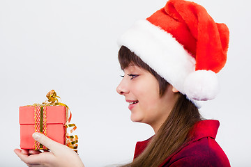 Image showing blue-eyed beautiful girl in santa hat with presents