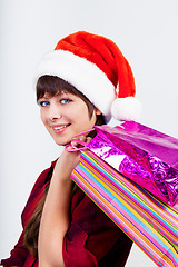 Image showing blue-eyed beautiful girl in santa hat with presents