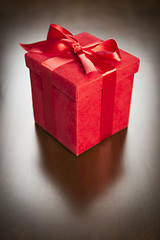 Image showing Red Gift Box with Ribbon and Bow Resting on Wood