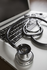 Image showing Medical Stethoscope Resting on Laptop Computer