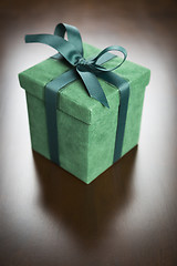 Image showing Green Gift Box with Ribbon and Bow Resting on Wood