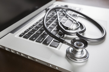 Image showing Medical Stethoscope Resting on Laptop Computer