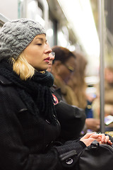 Image showing Woman napping on subway full of people.