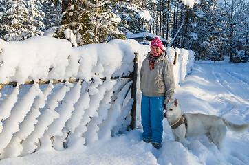 Image showing The woman with a dog on walk in a winter wood