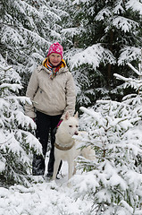 Image showing The woman with a dog on walk in a winter wood