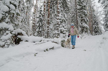 Image showing The woman with a dog on walk in a winter wood