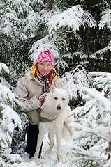 Image showing The woman with a dog on walk in a winter wood