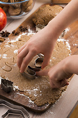 Image showing Close up little hands making the gingerbread cookies