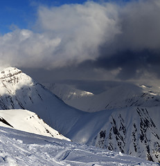 Image showing Off-piste slope and mountains with storm clouds