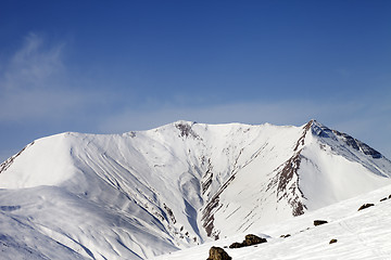 Image showing Off-piste slope with stones and snowy mountains