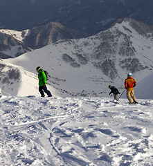 Image showing Snowboarders and skier on off-piste slope in sun evening