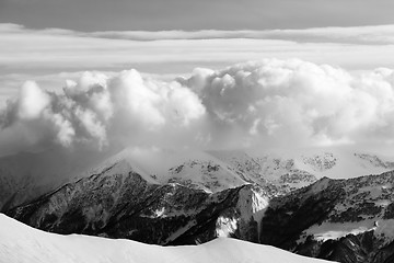 Image showing Black and white snowy mountains in clouds and off-piste slope