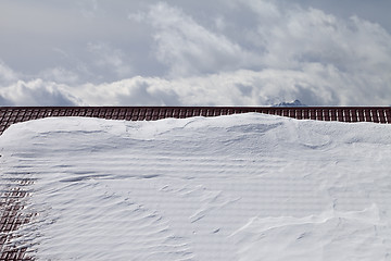 Image showing Snowy roof and cloudy sky