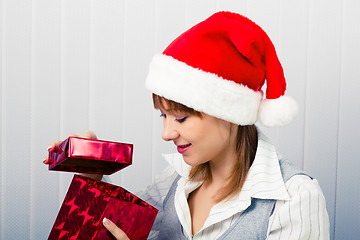 Image showing girl in the office in Santa hats with a gift