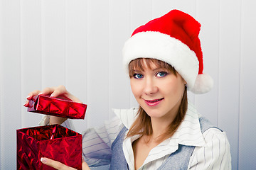 Image showing girl in the office in Santa hats with a gift