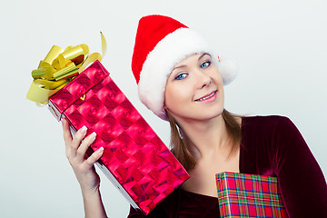 Image showing happy girl in santa hat with gift boxes