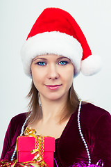 Image showing happy girl in santa hat with gift boxes