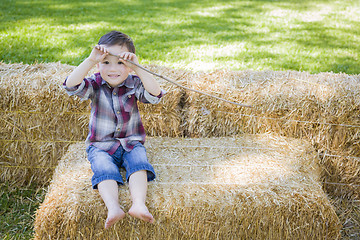 Image showing Cute Young Mixed Race Boy Having Fun on Hay Bale