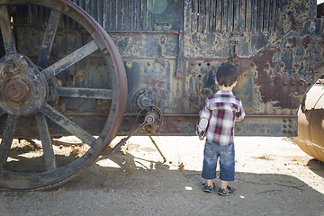 Image showing Cute Young Mixed Race Boy Having Fun Near Antique Machinery