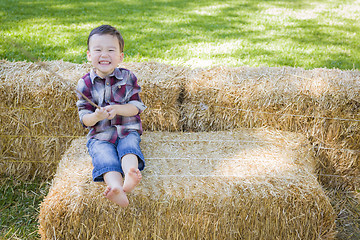 Image showing Cute Young Mixed Race Boy Having Fun on Hay Bale