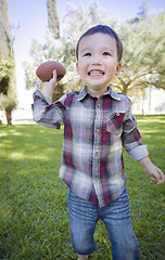 Image showing Cute Young Mixed Race Boy Playing Football Outside