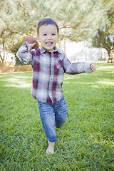 Image showing Cute Young Mixed Race Boy Playing Football Outside