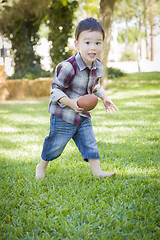 Image showing Cute Young Mixed Race Boy Playing Football Outside