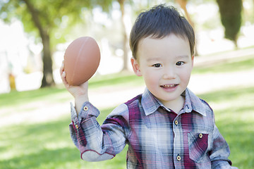 Image showing Cute Young Mixed Race Boy Playing Football Outside