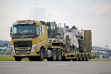 Image showing Yellow Volvo FH Hauls Heavy Machinery