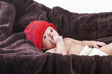 Image showing Surprising baby boy over brown blanket