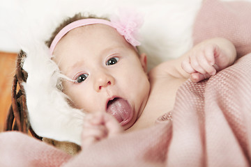 Image showing Baby puts out tongue