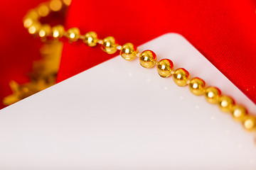 Image showing card. Red fabric with festive beads