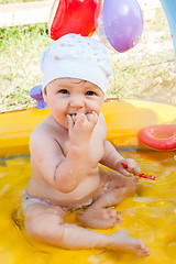 Image showing Little 9 monthes old girl swims in pool