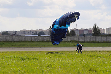 Image showing the parachutist lands on a multi-colored parachute.