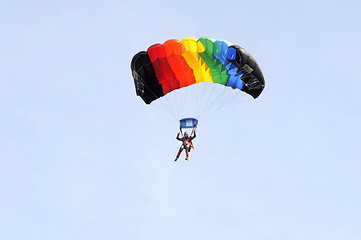 Image showing the parachutist goes down on a multi-colored parachute.