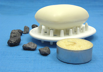 Image showing Beige soap with decoration articles on a light blue background