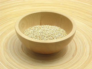 Image showing Wooden bowl with quinoa on bamboo plate