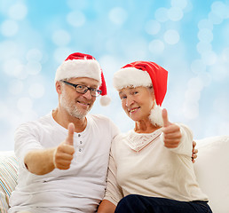 Image showing happy senior couple in santa helper hats