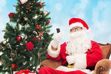 Image showing santa claus with smartphone and christmas tree