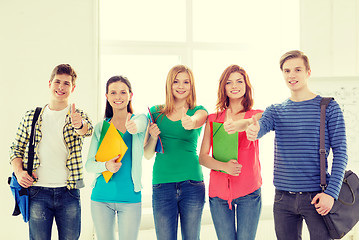 Image showing smiling students with bags and folders at school