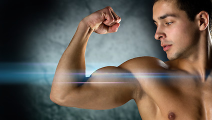 Image showing close up of young man flexing and showing biceps
