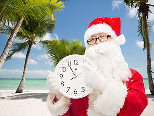 Image showing man in costume of santa claus with clock