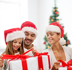 Image showing happy family in santa helper hats with gift boxes