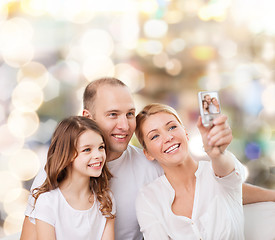 Image showing happy family with camera at home