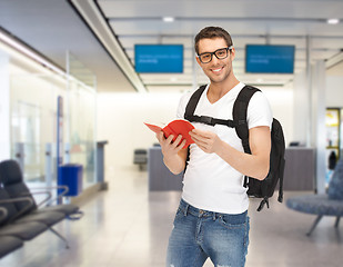 Image showing smiling student with backpack and book at airport