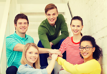 Image showing smiling students with hands on top of each other