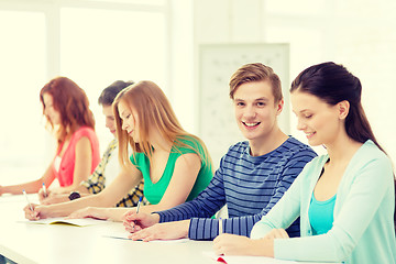 Image showing smiling students with textbooks at school