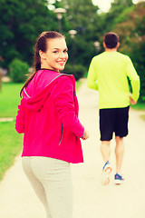 Image showing smiling couple running outdoors